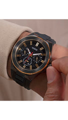 GUESS BR GUN CS W/BR GLD TR W/BR GUN TOP/SUN BLK MF DL/BLK TEXTURED SILICONE STRP